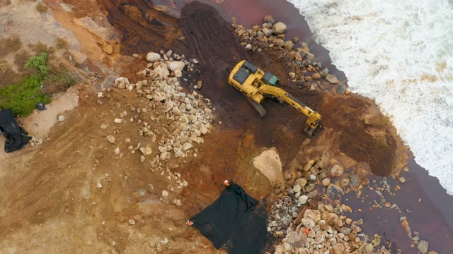 LA PLAYITA LOS CABOS MEXICO-2021: Excavator Moving Rocks at Water's Edge