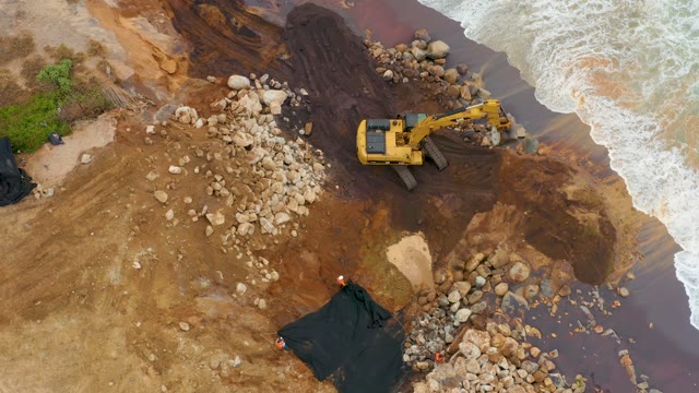 LA PLAYITA LOS CABOS MEXICO-2021: Excavator Operating on Muddy Coastal Shore