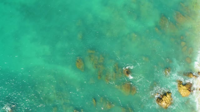 EL TULE BEACH LOS CABOS BCS MEXICO-2021: Waves Lapping Against Rocky Coast in Clear Turquoise Water