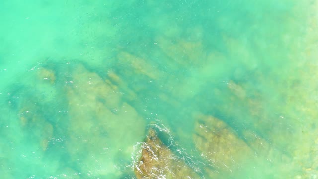 EL TULE BEACH LOS CABOS BCS MEXICO-2021: Gentle Waves Over Clear Turquoise Water and Submerged Rocks