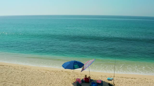 EL TULE BEACH LOS CABOS BCS MEXICO-2021: Beachgoers and Umbrellas Fading From Shoreline View
