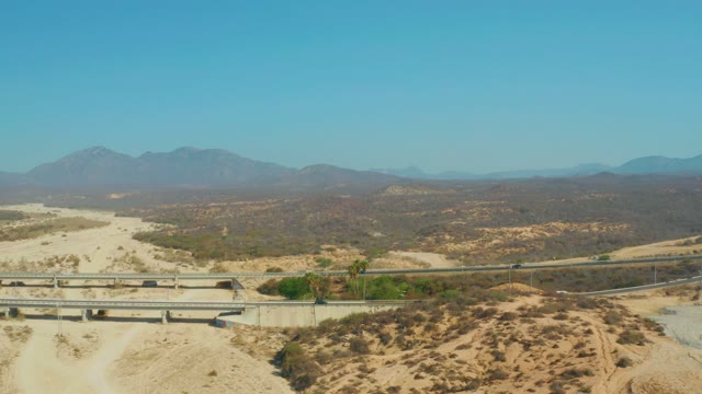 EL TULE BEACH LOS CABOS BCS MEXICO-2021: Desert Highway Traffic with Distant Mountains and Overpasses