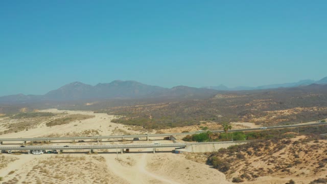 EL TULE BEACH LOS CABOS BCS MEXICO-2021: Arid Desert Highway with Overpass and Distant Mountains