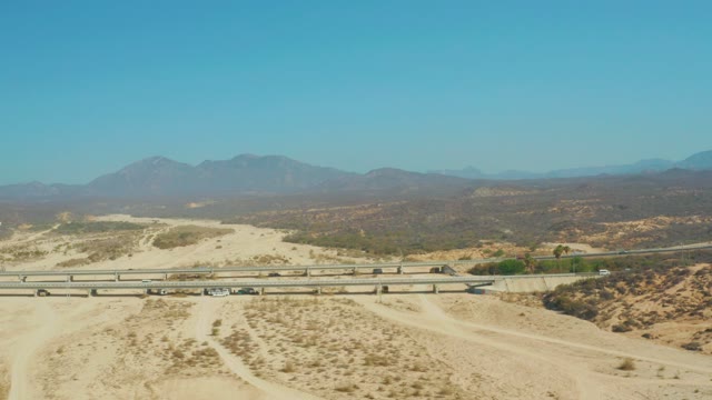 EL TULE BEACH LOS CABOS BCS MEXICO-2021: Desert Highway Traffic with Distant Mountain Range