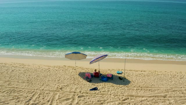 EL TULE BEACH LOS CABOS BCS MEXICO-2021: Beachgoers Relaxing Under Umbrellas by the Ocean