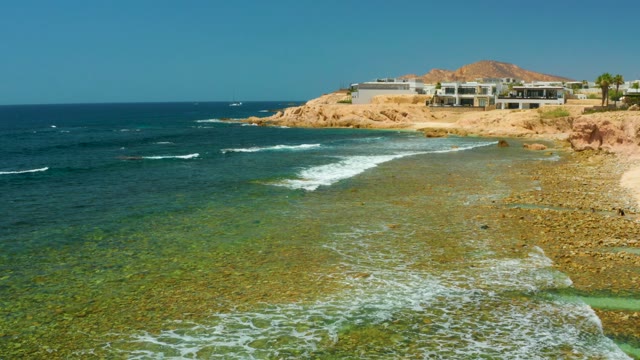 EL TULE BEACH LOS CABOS BCS MEXICO-2021: Ocean Waves Ebbing and Flowing on Rocky Shore