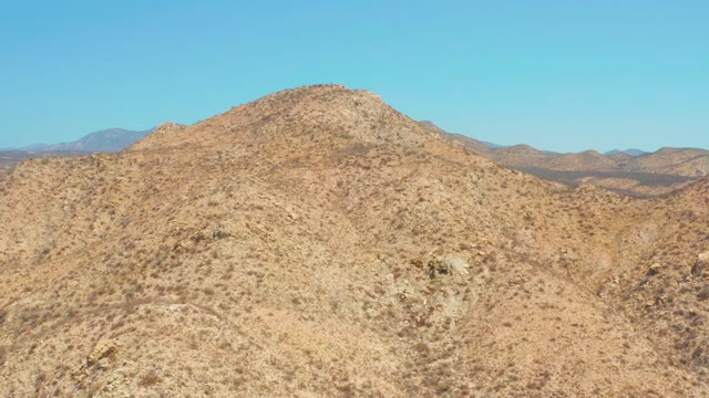 DREAMS LOS CABOS BCS MEXICO-2021: Arid Hill with Sparse Vegetation and Distant Mountains
