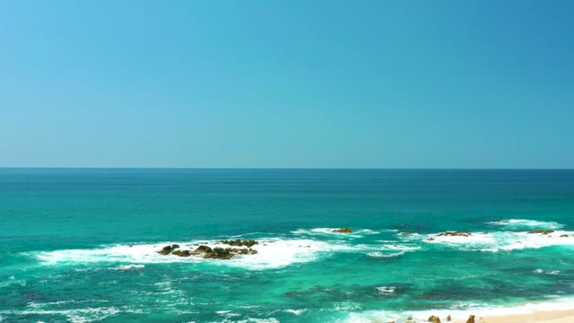 DREAMS LOS CABOS BCS MEXICO-2021: Waves Crashing on Rocky Shore with Beachgoers