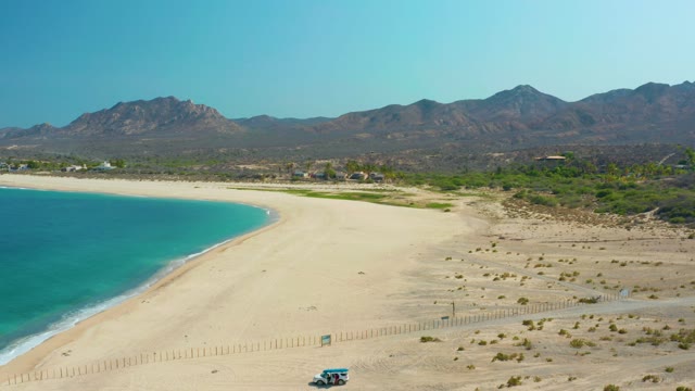 LOS FRALIES LOS CABOS BCS MEXICO-2021: Small Vehicle Driving Along Sandy Beach Shore
