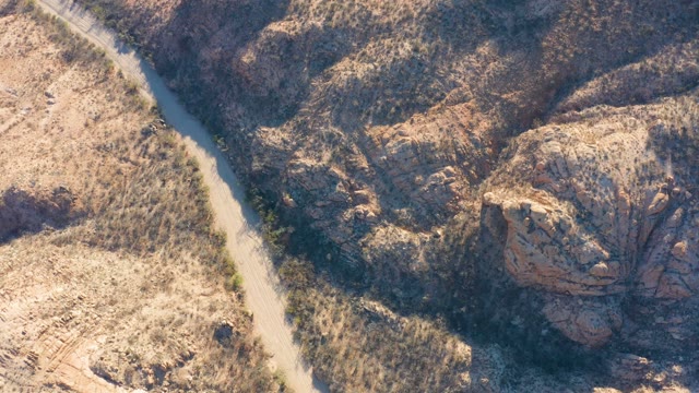 CABO PULMO BCS MEXICO-2021: Vehicle Traveling on Narrow Dirt Path Through Arid Rocky Terrain