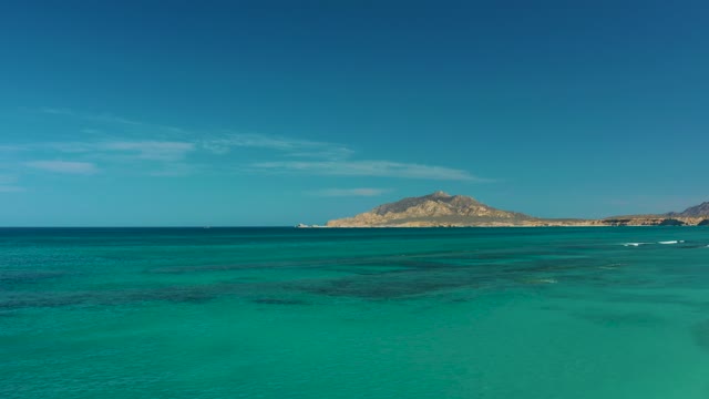 Gentle Waves in Clear Turquoise Ocean Near Distant Island