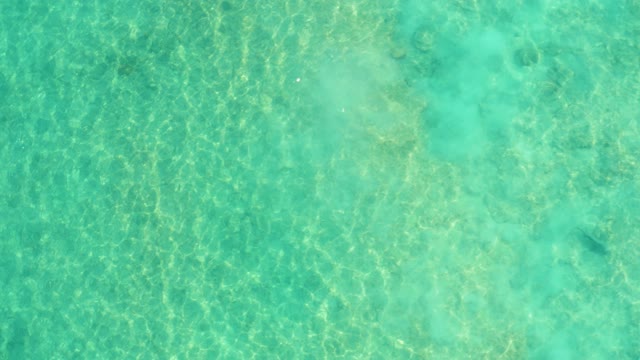 Clear Turquoise Ocean Water and Emerging Underwater Rocks