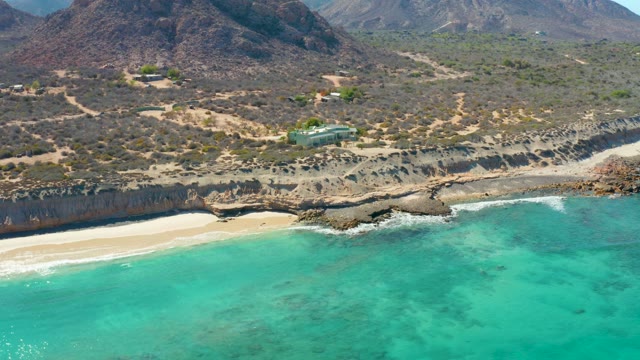 Coastal Cliff with Sandy Beach and Clear Turquoise Water