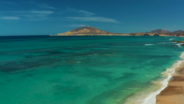 Gentle Waves Lapping Sandy Shore with Distant Island