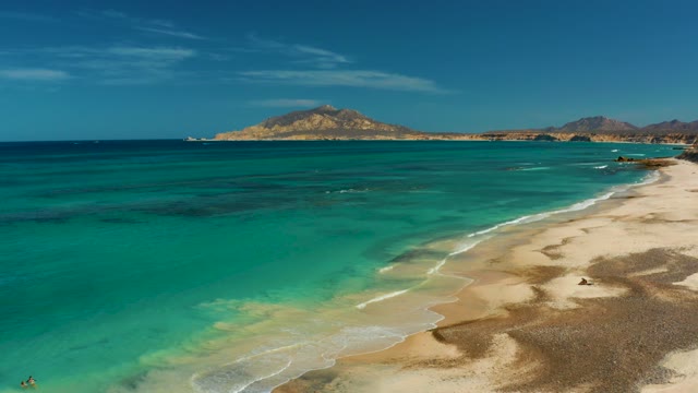 Gentle Waves Lapping a Sandy Beach with Clear Turquoise Water
