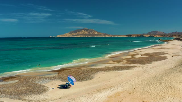 Beachgoers Relaxing on a Sandy Shore with Turquoise Ocean