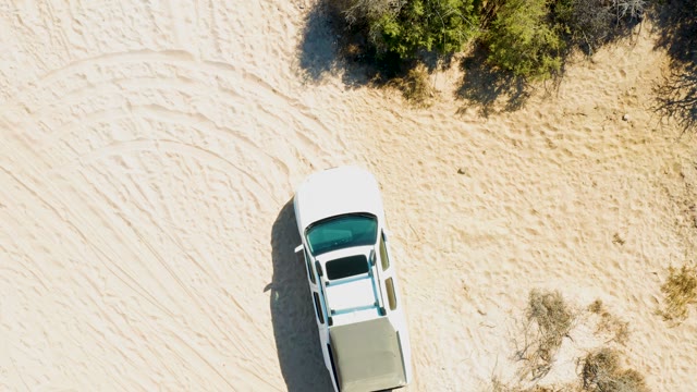 White Car Driving on Sandy Desert Terrain