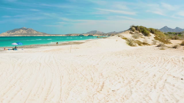 Beachgoers Walking by Turquoise Ocean