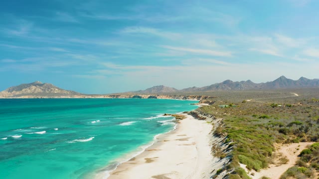 Turquoise Waters and Sandy Beach Along Rocky Coastline