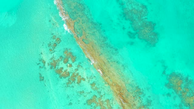 Narrow Sandbar and Gentle Waves in Clear Turquoise Water