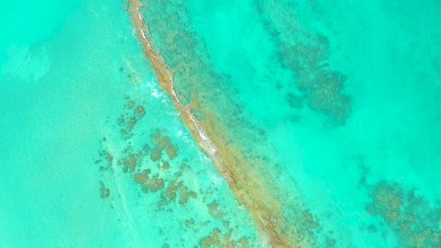 Waves Breaking Along Narrow Sandbar in Turquoise Water