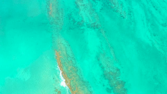 Narrow Sandbar in Clear Turquoise Ocean with Wave Motion