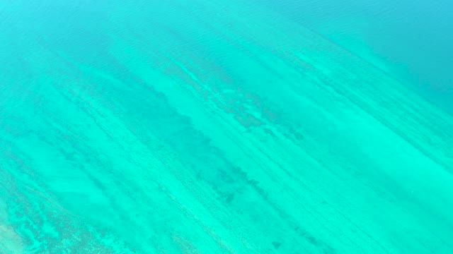 Clear Turquoise Water Over Sandy Seabed with Sunlight Ripples