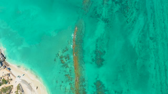 Boat Moving From Sandy Beach Into Turquoise Ocean