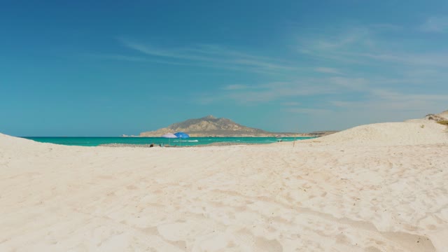 CABO PULMO BCS MEXICO-2021: People Relaxing Under Blue Umbrella on Sandy Beach