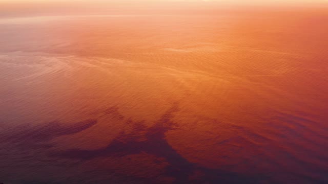 CABO PULMO BCS MEXICO-2021: Sunset-tinged Ocean Surface with Oil Sheen Ripples
