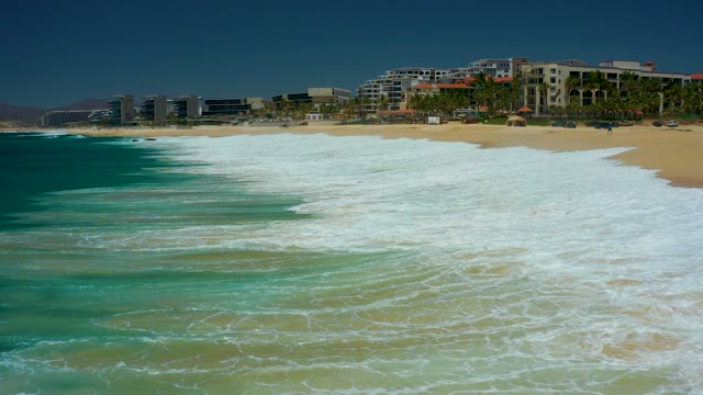 MARQUIS LOS CABOS BCS MEXICO-2021: Waves Crashing on Sandy Beach with Coastal Buildings