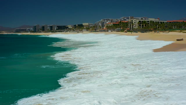 MARQUIS LOS CABOS BCS MEXICO-2021: Waves Rolling Onto Sandy Beach with Coastal Buildings