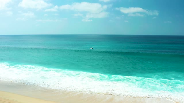 MARQUIS LOS CABOS BCS MEXICO-2021: Surfer Gliding on Turquoise Ocean Waves Near Shore