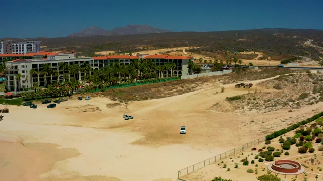 DREAMS LOS CABOS BCS MEXICO-2021: White Car Moving Along a Dirt Road near Buildings