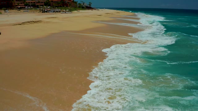 DREAMS LOS CABOS BCS MEXICO-2021: Waves Rolling Onto Sandy Beach Shoreline
