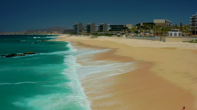 DREAMS LOS CABOS BCS MEXICO-2021: Man Walking Along Sandy Beach with Turquoise Ocean