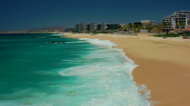 DREAMS LOS CABOS BCS MEXICO-2021: Ocean Waves Advancing and Receding on Sandy Beach