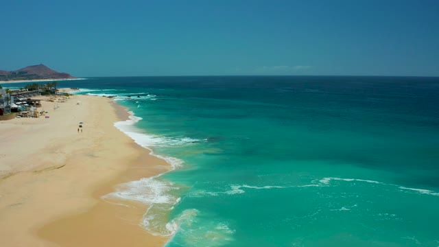 DREAMS LOS CABOS BCS MEXICO-2021: Gentle Ocean Waves Lapping Sandy Beach with a Person Walking