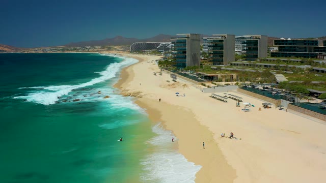 DREAMS LOS CABOS BCS MEXICO-2021: Waves Breaking on a Sandy Shore with Coastal Buildings