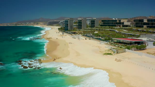DREAMS LOS CABOS BCS MEXICO-2021: Waves Rolling Onto Sandy Beach with People Walking