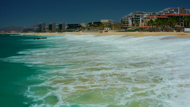 DREAMS LOS CABOS BCS MEXICO-2021: Waves Advancing Toward Sandy Beach Shoreline