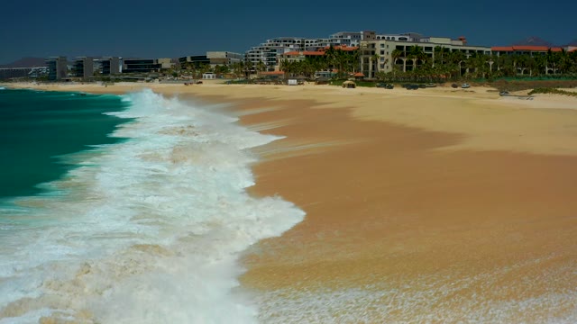 DREAMS LOS CABOS BCS MEXICO-2021: Waves Crashing Onto Sandy Beach Shoreline