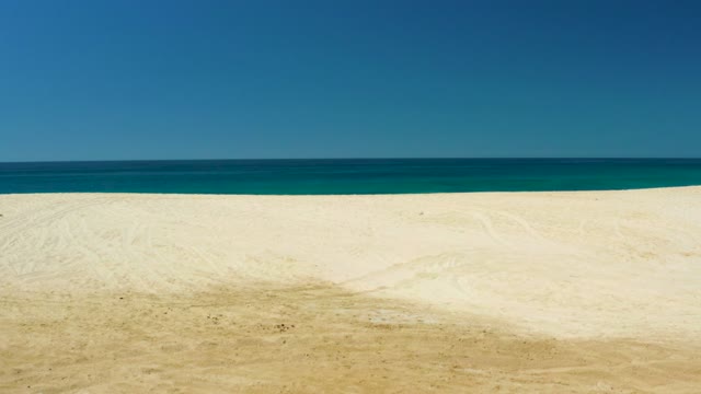 DREAMS LOS CABOS BCS MEXICO-2021: Sandy Beach with Receding Ocean and Approaching Vehicle