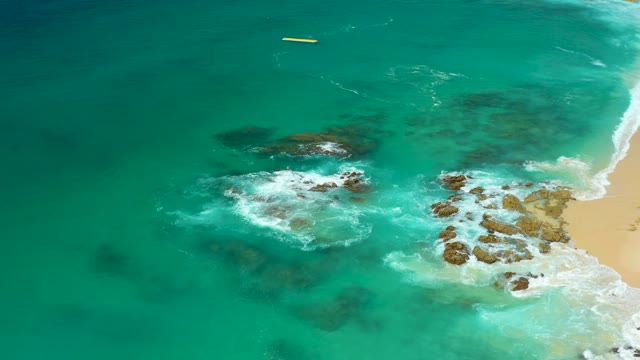 DREAMS LOS CABOS BCS MEXICO-2021: Waves Crashing on Rocky Shoreline with Turquoise Water