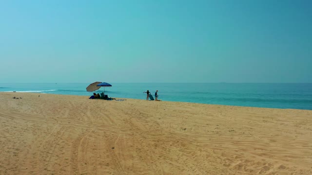SHIPWRECKS LOS CABOS BCS MEXICO-2021: Beachgoers Moving near Ocean with Umbrella
