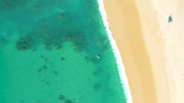 SHIPWRECKS LOS CABOS BCS MEXICO-2021: Person Walking Along Sandy Beach Beside Clear Turquoise Ocean