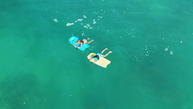 SHIPWRECKS LOS CABOS BCS MEXICO-2021: Two People Floating on Boards in Clear Ocean Water