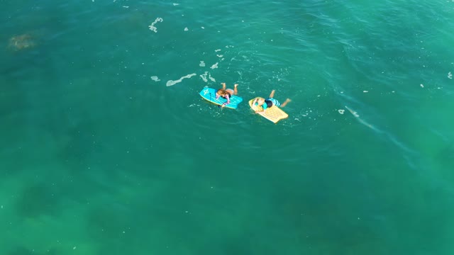 SHIPWRECKS LOS CABOS BCS MEXICO-2021: Two People Floating on Bodyboards in Clear Ocean Water