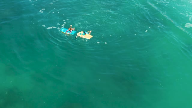 SHIPWRECKS LOS CABOS BCS MEXICO-2021: Two People Floating on Bodyboards in Clear Ocean Water