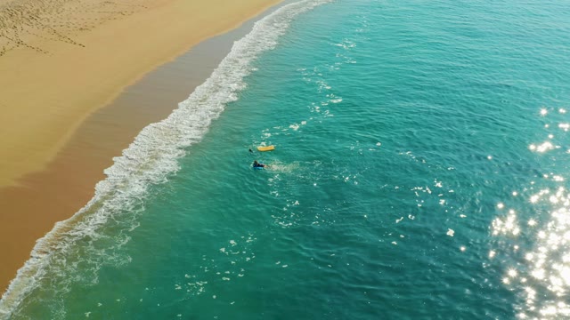 SHIPWRECKS LOS CABOS BCS MEXICO-2021: Two Bodyboarders Paddling in Shallow Ocean near Sandy Beach
